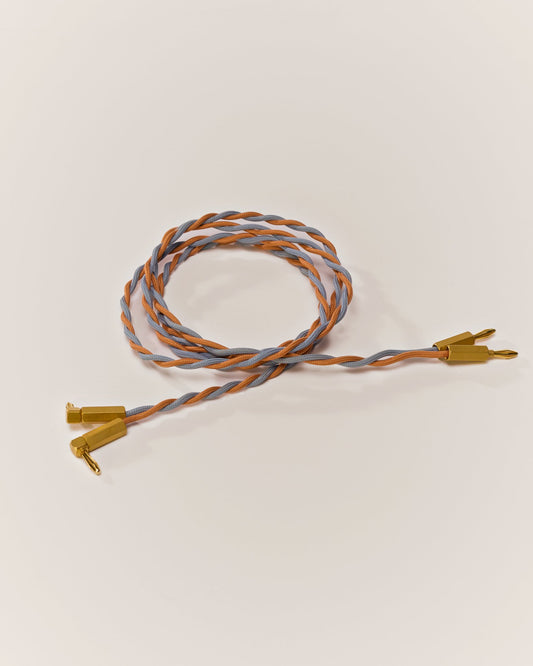Braided Speaker Wire in Sky Blue & Salmon, coiled, with gold-plated banana plugs